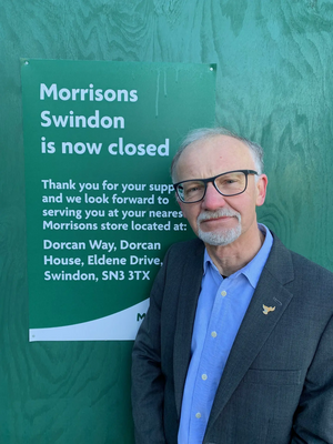 Councillor Stan Pajak standing next to the Morrisons closure sign